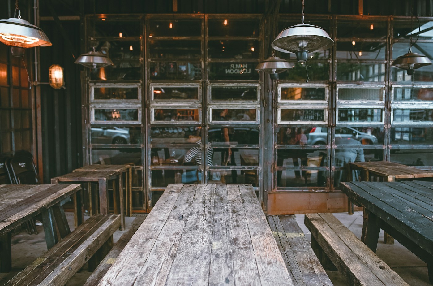 Rustic dining space with wooden tables and warm overhead lamps